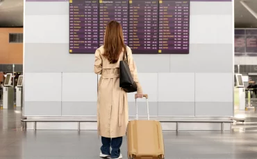 Femme devant le tableau d'un aéroport